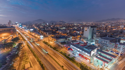 Aerial view of Via Expresa highway and metropolitan bus with traffic day to night timelapse. Lima, Peru