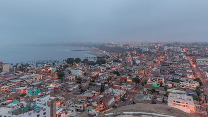 Naklejka premium Panoramic skyline of Lima city from above with many buildings aerial night to day transition timelapse. Lima, Peru