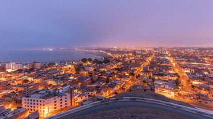 Panoramic skyline of Lima city from above with many buildings aerial night to day transition timelapse. Lima, Peru
