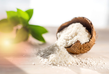 coconut flakes lies in a coconut shell, cut into two halves