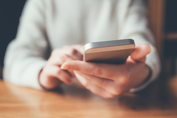 Women's hands use a smartphone for online shopping, social networking, or remote work. Close up image.