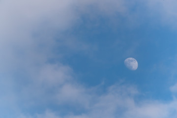 Three Quarter Moon in a Blue Sky with Clouds