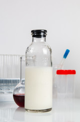 Glassware with white liquids, test-tube and flask for laboratory analysis. Laboratory medical research, chemical lab.
