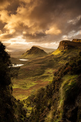 Scenic view of Quiraing mountains in Isle of Skye, Scottish highlands, United Kingdom. Sunrise time with colourful an rayini clouds in background. - 338045159