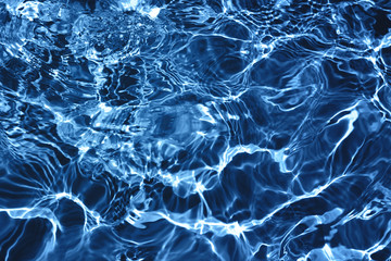 Closeup of rough water surface texture with splashes and bubbles in dark blue color. Trendy fresh abstract nature background. 2020 color concept