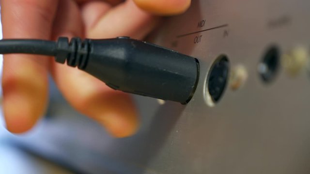Close-up Macro Male Hand Plugging Cable in MIDI Port. Musical Instrument Audio Interface Synthesizer Keyboard. 2x Slow motion 0.5 speed 60 FPS 4K
