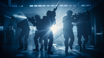 Masked Fireteam of Armed SWAT Police Officers Storm a Dark Seized Office Building with Desks and Computers. Soldiers with Rifles and Flashlights Move Forwards and Cover Surroundings. - obrazy, fototapety, plakaty