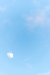 Obraz premium Three Quarter Moon in a Blue Sky with Clouds