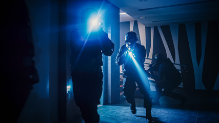 Masked Squad of Armed SWAT Police Officers Move Out from the Elevator and Storm the Corridor of an Office Building. Soldiers with Rifles and Flashlights Move Forwards and Cover Surroundings. 