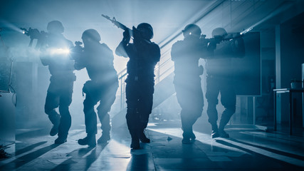 Masked Team of Armed SWAT Police Officers Move in a Hall of a Dark Seized Office Building with...
