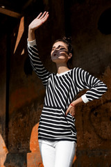 Beauty Fashion Model Girl with Brown Hair on a background of an old, abandoned building, wearing stylish clothes.