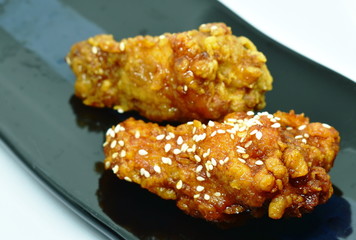 crispy fried chicken drum wing with Korean sauce and Sichuan pepper topping white sesame on plate