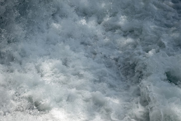 Flowing water and spray in river with sunlight for background, copy space and wallpaper