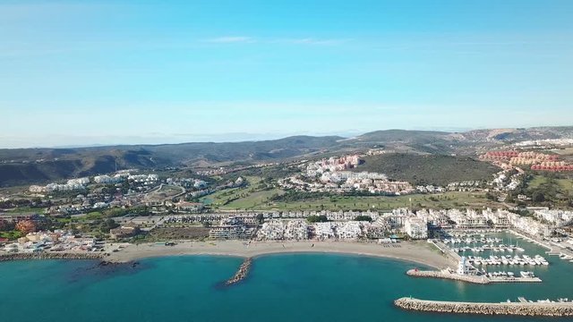 Aerial panoramic view of beautiful "Puerto de la Duquesa" in MANILVA- Malaga SPAIN. Yachts and boats docked in the Harbour. Luxury Apartment Urbanisation and Restaurants. Truck Right