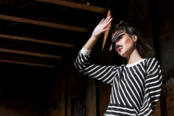 Beauty Fashion Model Girl with Brown Hair on a background of an old, abandoned building, wearing stylish clothes.