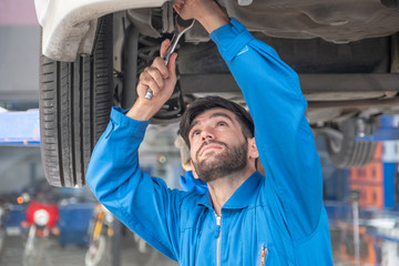 Mechanic are fixing the undercarriage by car lifting. Worker are maintenance undercarriage by car lifting.