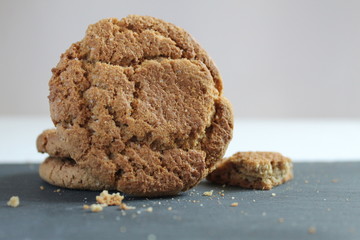 a large round cookie is stacked on top of each other and next to it is a cookie and a piece on a gray stone on a white background with a place to insert text