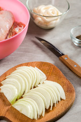 Chicken thighs with onions and mayonnaise, a simple recipe for homemade attraction, preparation for baking.