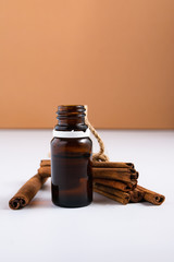 natural cosmetics concept, composition of glass bottles with oil and cinnamon sticks on a white background