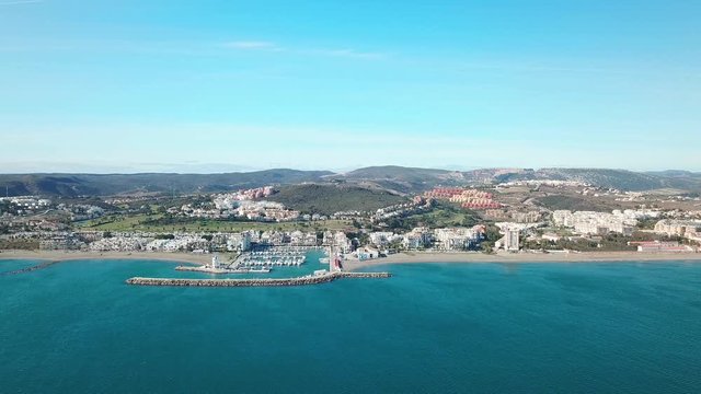 Beautiful Aerial panoramic view of "Puerto de la Duquesa" and city of MANILVA- Malaga SPAIN. Yachts and boats docked in the Harbour. Luxury Apartment Urbanisation and Restaurants. Empty beaches.