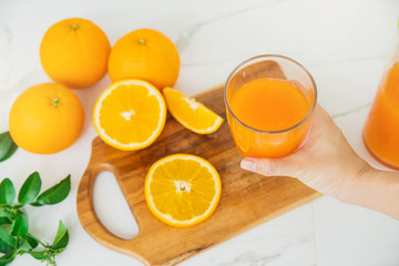 Freshly squeezed orange juice for health. Orange juice pouring pour oranges fruit fruits drink. Fresh orange juice with oranges fruit in kitchen.