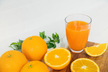 Freshly squeezed orange juice for health. Orange juice pouring pour oranges fruit fruits drink. Fresh orange juice with oranges fruit in kitchen.