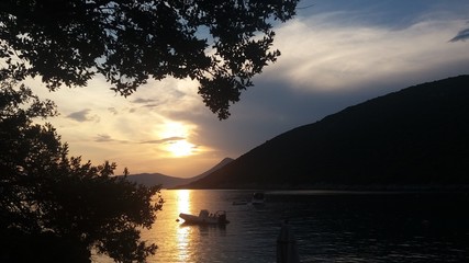 Naklejka na ściany i meble Sundown with boat at Montenegro beach