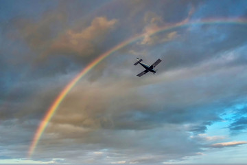 Small Private Prop Plane Flying in the Sky with Rainbow