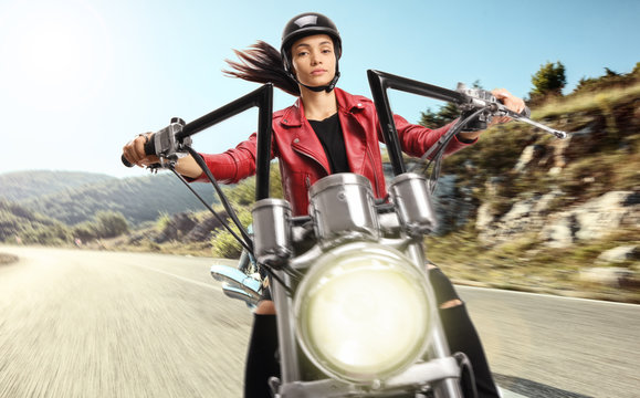 Young woman riding a chopper motorbike on an open road