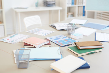 Background image of empty office workplace with documents and charts on white desk, copy space