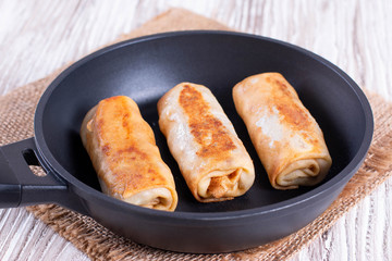 Frying pan with fried pancake roll