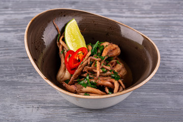 Boiled octopus with greens and red pepper, served with a slice of lime