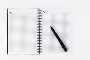Empty stylish spiral Notepad for notes and a beautiful corporate pen on a white background. Stylized stock photos. The view from the top.