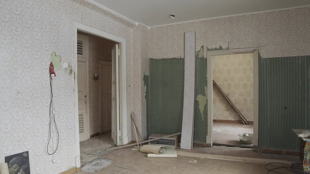 Repair in apartment Old abandoned room apartment under reconstruction Dirty floors carpets torn white wallpapers batteries Old cabinet mirror Panorama left right Transfer repair show Interior designer