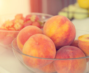 Peaches in a glass dish.