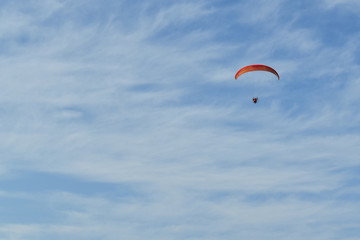 Blue cloudy sky with a paraglider