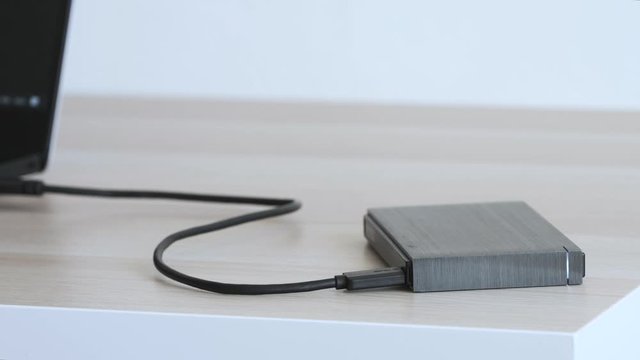 External Hard Drive On a Table, Led Light Flickering - Solid Aluminium Casing HDD, Minimalist Design Composition - Macro Closeup