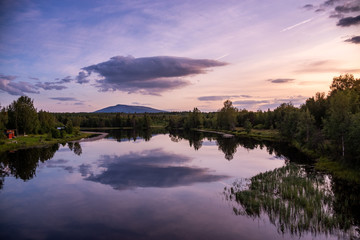 mystic cloud over a mountain in sweden with clean reflection in the lake or river in foreground