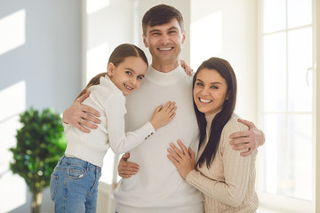 Happy smiling family. Daughter mother and father smiling hugging cheerful in a room at home.