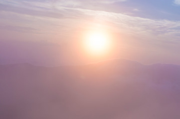 Obraz premium sunset in the mountains, mountains in the clouds in a haze
