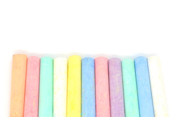 Multi-colored crayons on a white background. Colored chalk. Wallpaper. Art supplies. Children's stationery. The tool of the artist. Materials for creativity. Hobby goods.