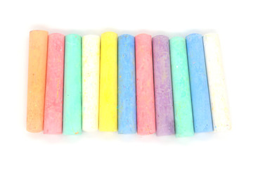 Multi-colored crayons on a white background. Colored chalk. Wallpaper. Art supplies. Children's stationery. The tool of the artist. Materials for creativity. Hobby goods.