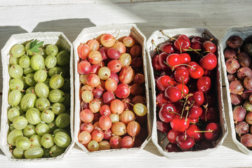 organic fruit stand with seasonal fruits and berries in the local market of the city. Fruits in paper baskets on market place