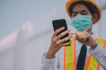Foreman using mobile smart phone on site construction
