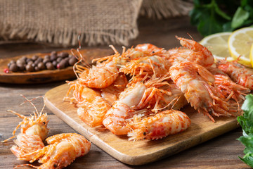 Shrimp on a wooden Board on a brown wooden table. Greenlandic prawns