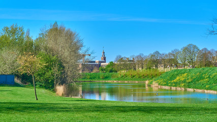Church and military tower behind the river in old town. Hellevoetsluis. Holland