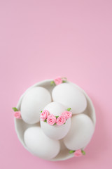 White eggs in bowl on pink background