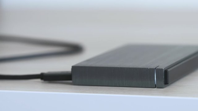 Closeup of Metalic External Hard Drive On a Table, Led Light Flickering - Minimalist Composition