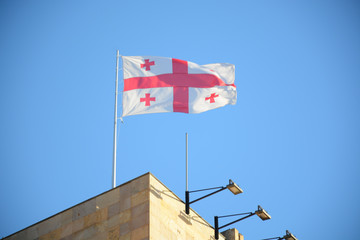 Tbilisi, Georgia - October 4, 2018: Georgean flag near Metekhi St. Virgin Church and Statue of King Vakhtang Gorgasali