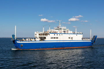 Ferry transports people and cars on a Sunny day